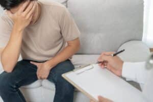 Man with hands over eyes speaking with doctor about prostate cancer screening in Hartford