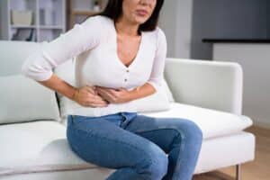 Woman holding her stomach in pain from UTI in Hartford, CT