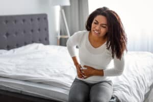 Woman on bed in pain from UTI in Hartford, CT