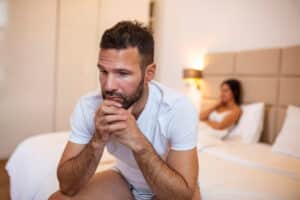 Man on bed looking distressed because of erectile dysfunction in Hartford, CT