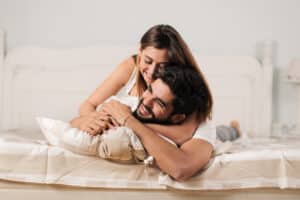 Happy couple cuddling up in bed after man's vasectomy in Hartford, CT